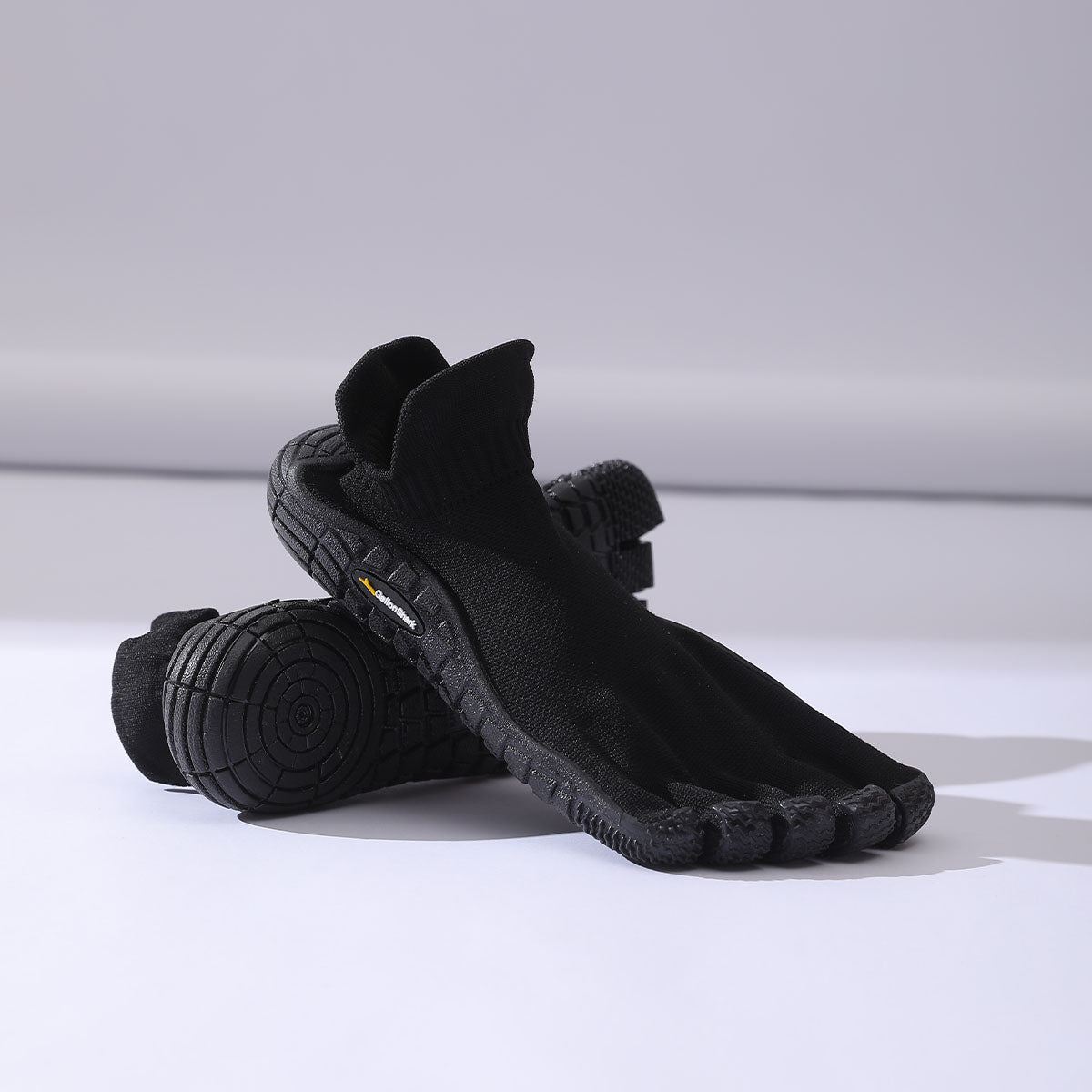 Zapatillas barefoot negras de cinco dedos para entrenamiento funcional y fitness.